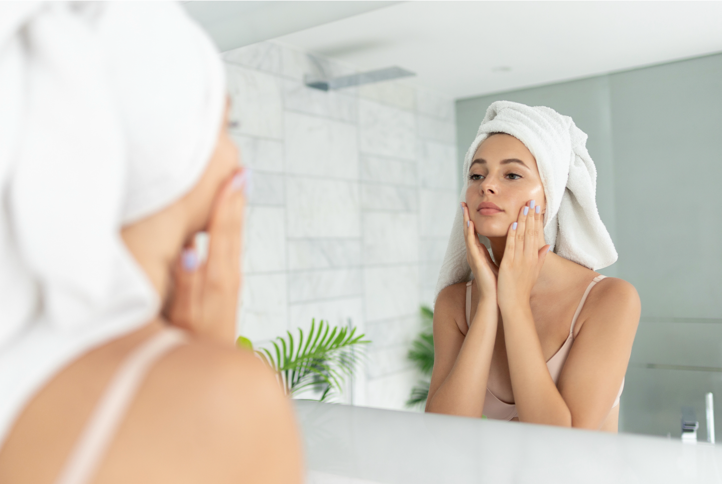 woman in the mirrors looking at her skin