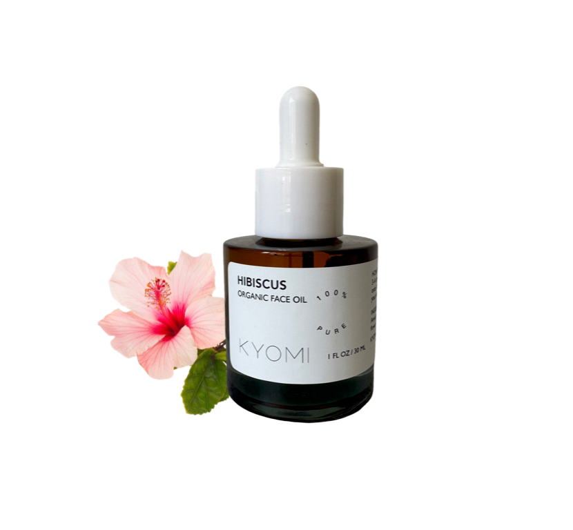 Bottle of KYOMI hibiscus organic face oil with a pink flower on a white background