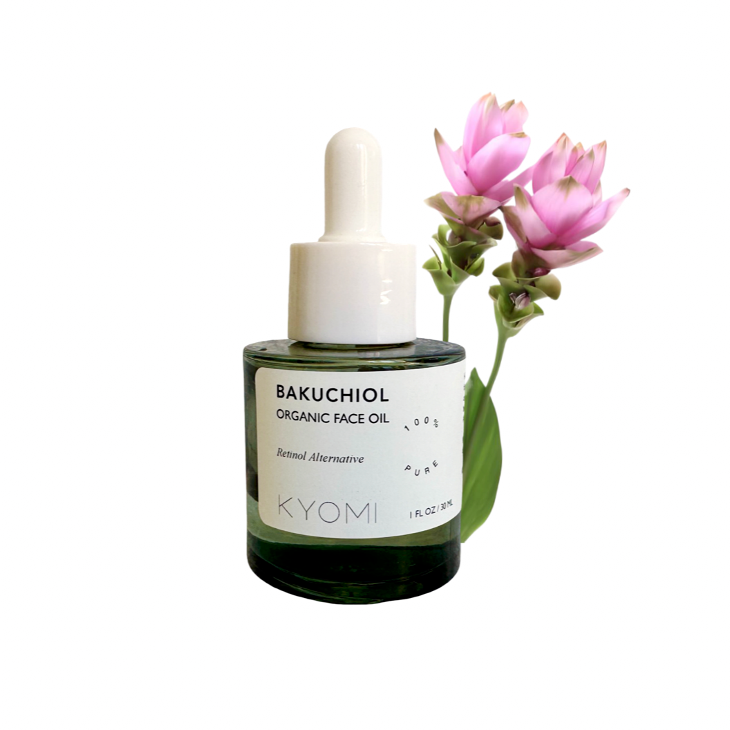 Bottle of KYOMI Bakuchiol Organic Face Oil with a pink flower on a white background