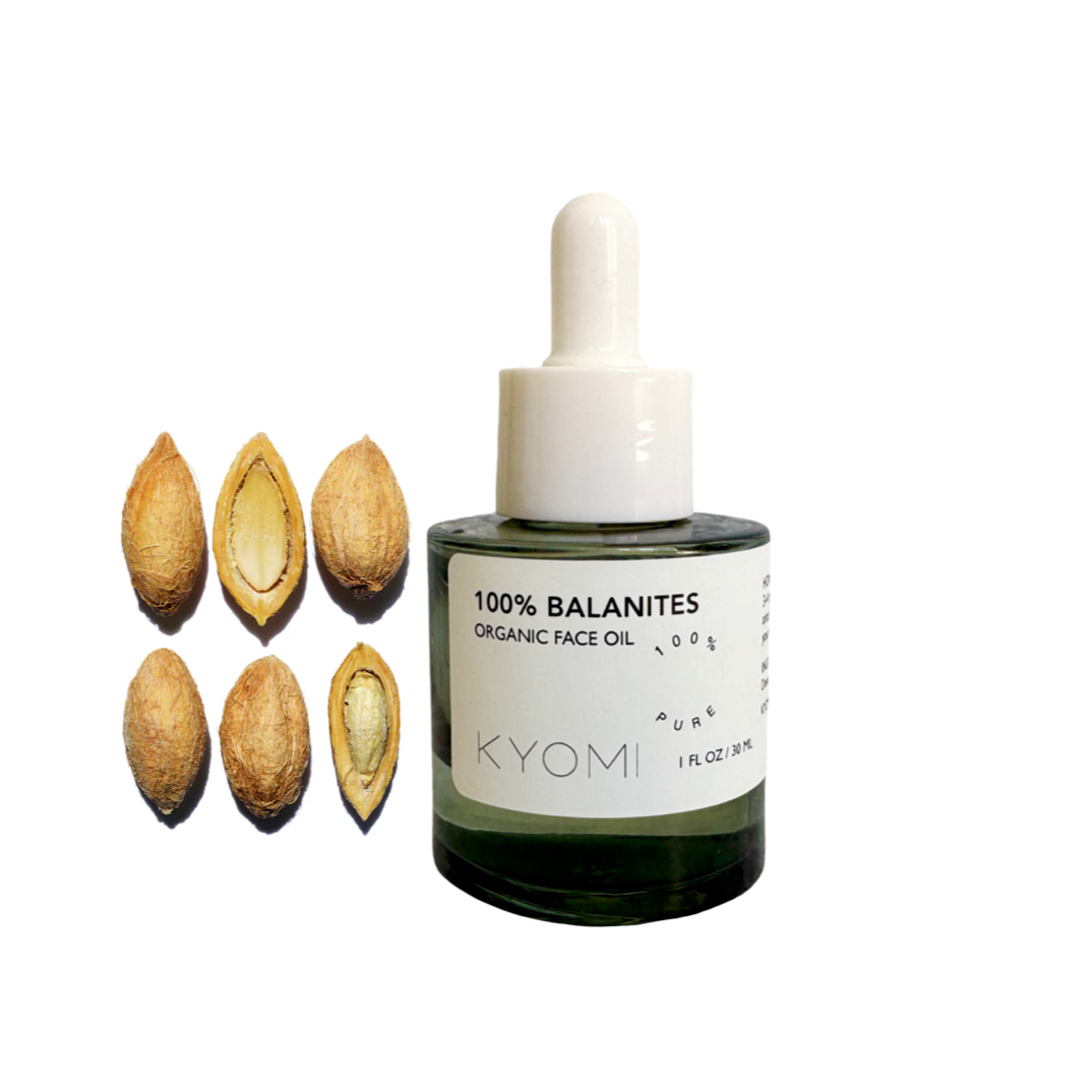 KYOMI organic face oil bottle with dried balanites seeds on a white background