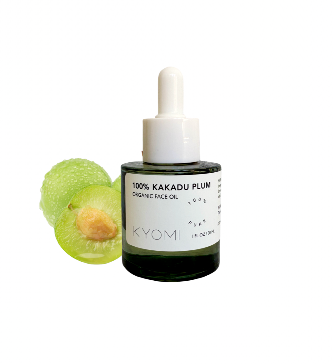 Bottle of KYOMI 100% Kakadu Plum Organic Face Oil with a green fruit on a white background