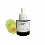 Bottle of KYOMI 100% Kakadu Plum Organic Face Oil with a green fruit on a white background