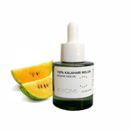 Bottle of KYOMI 100% Kalahari Melon organic face oil with two slices of melon on a white background