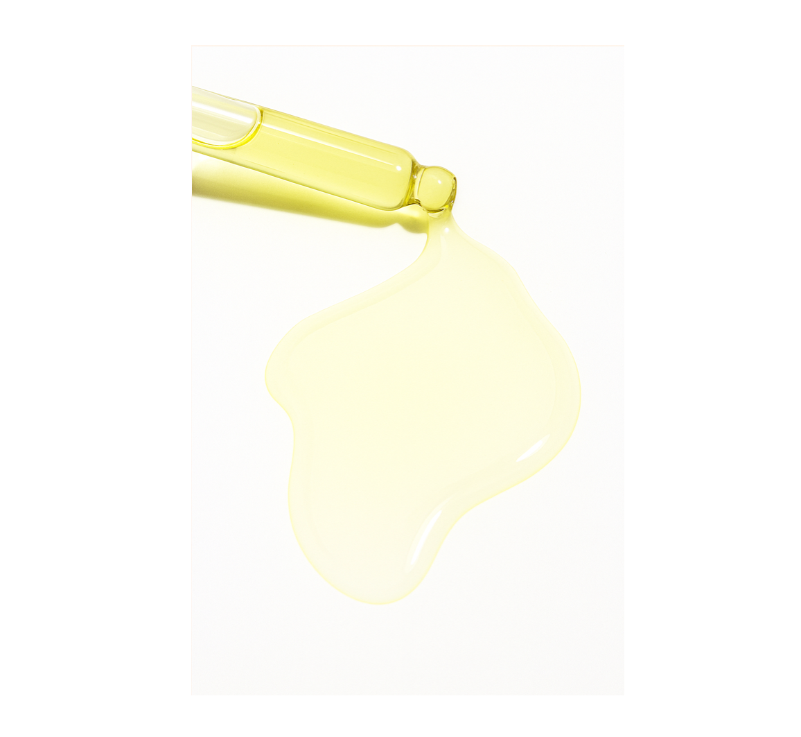 Yellow dropper bottle with liquid on a white background