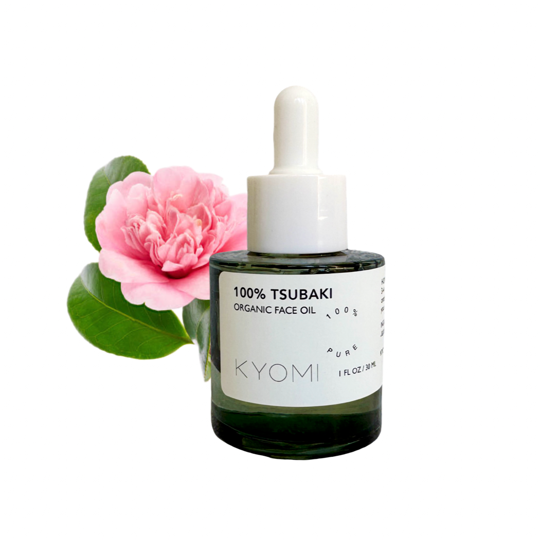 Bottle of KYOMI 100% Tsubaki Organic Face Oil with a pink flower on a white background