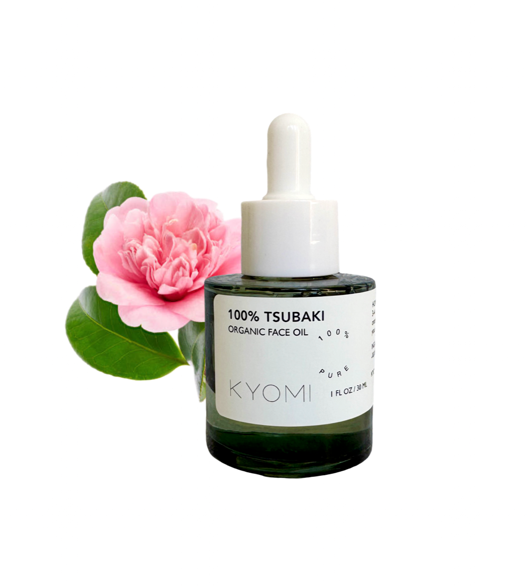 Bottle of KYOMI 100% Tsubaki Organic Face Oil with a pink flower on a white background