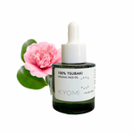 Bottle of KYOMI 100% Tsubaki Organic Face Oil with a pink flower on a white background